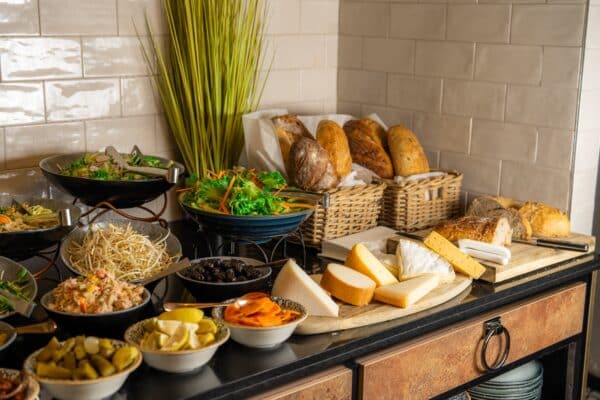 Assorted fresh salads cheeses and bread baskets on the Abba Hotel Tel Aviv breakfast buffet