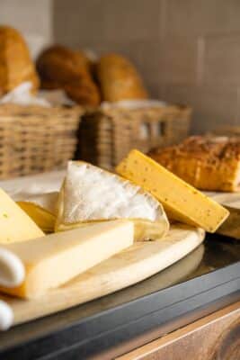 Cheese selection on a wooden board with rustic loaves in baskets at the Abba Hotel buffet