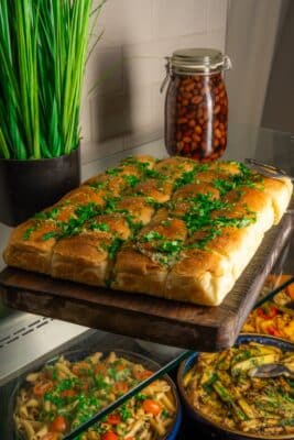 Fresh garlic and parsley bread rolls on a wooden board at the Abba Hotel breakfast buffet