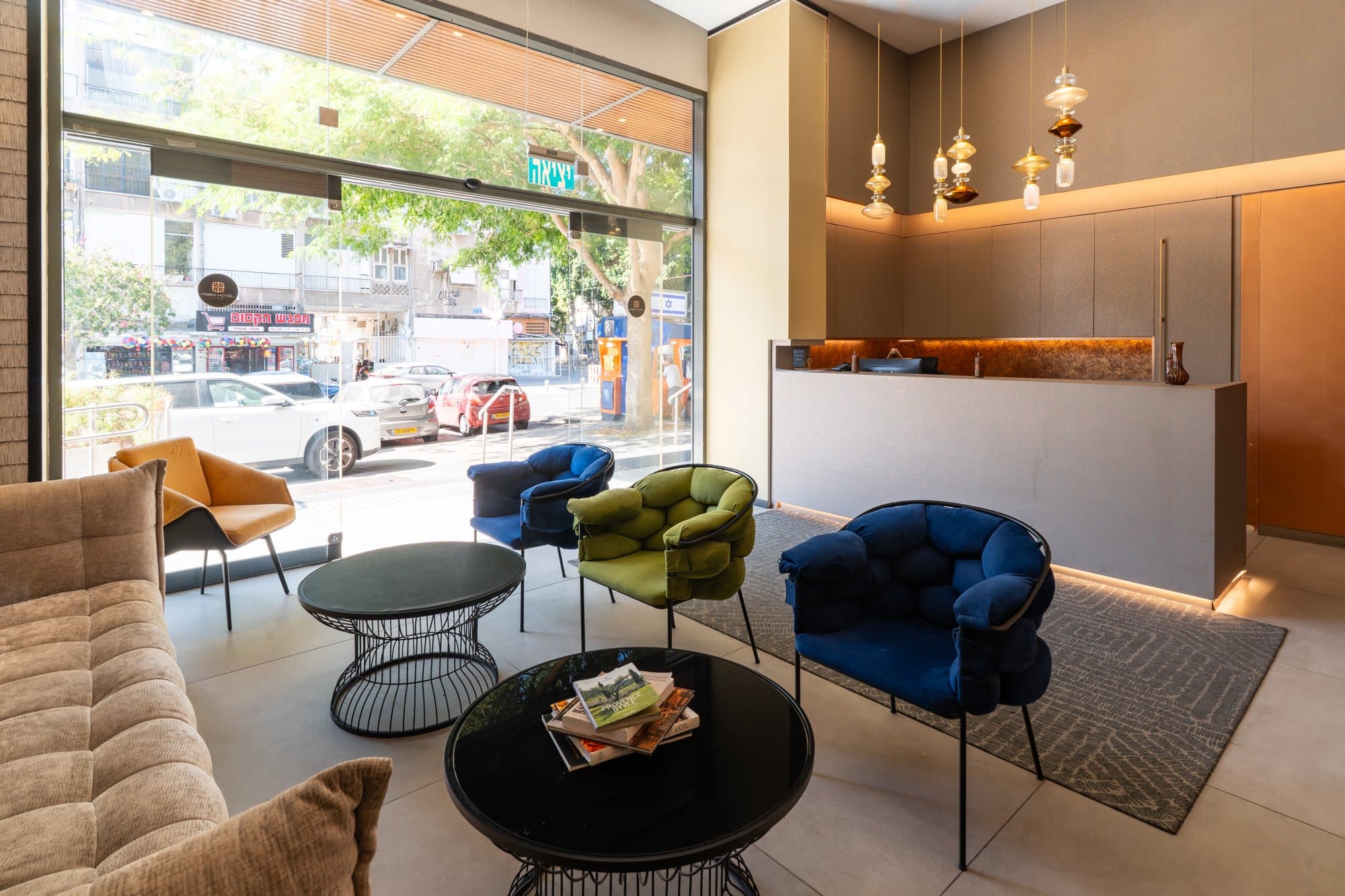 Abba Hotel Tel Aviv-Yafo lobby with velvet armchairs coffee tables reception desk and street windows